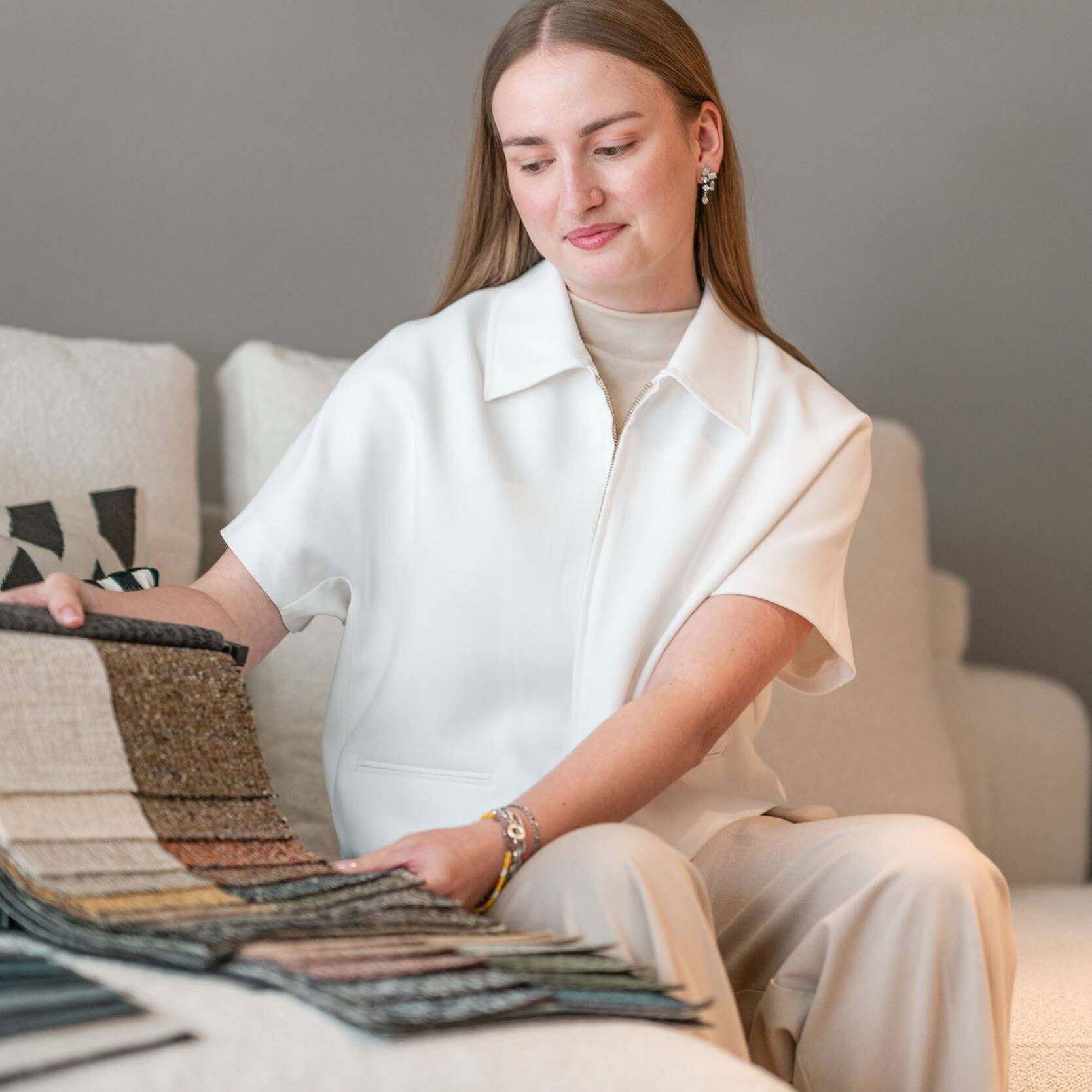Beraterin mit Stoffmustern auf einem Sofa im Showroom Oberkassel